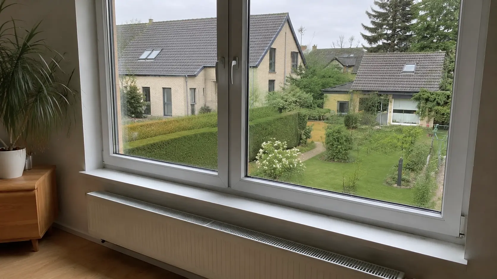 Streifenfrei gereinigtes Fenster mit klarem Blick in den Garten